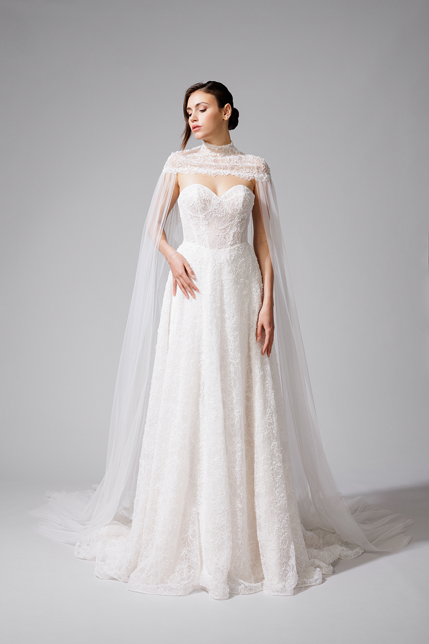 BEL22714_1 copie Robe de mariée BEL22714 en dentelle rebrodée de perles et de sequins avec cape amovible. Collection Bella 2027.